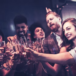 Private Events A group of people cheerfully clinking champagne glasses together at a party or social gathering.